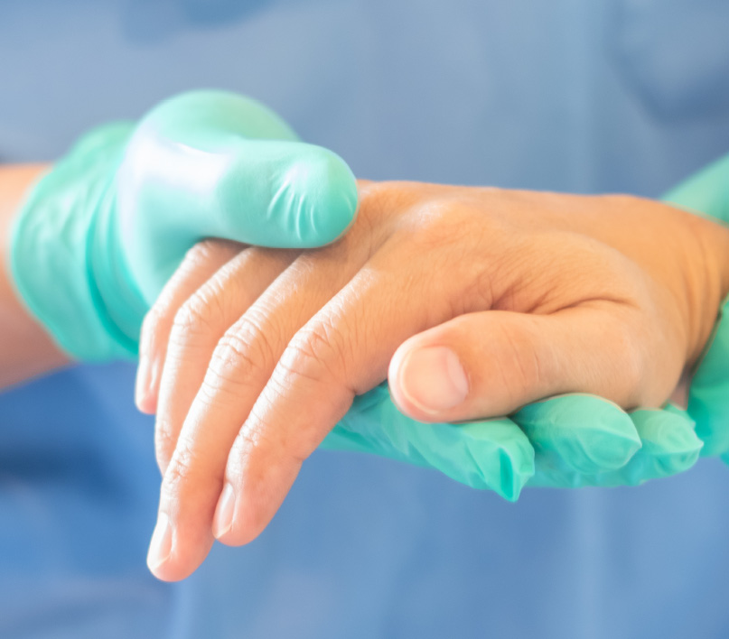 Clinician examining a patient's hand during a consultation